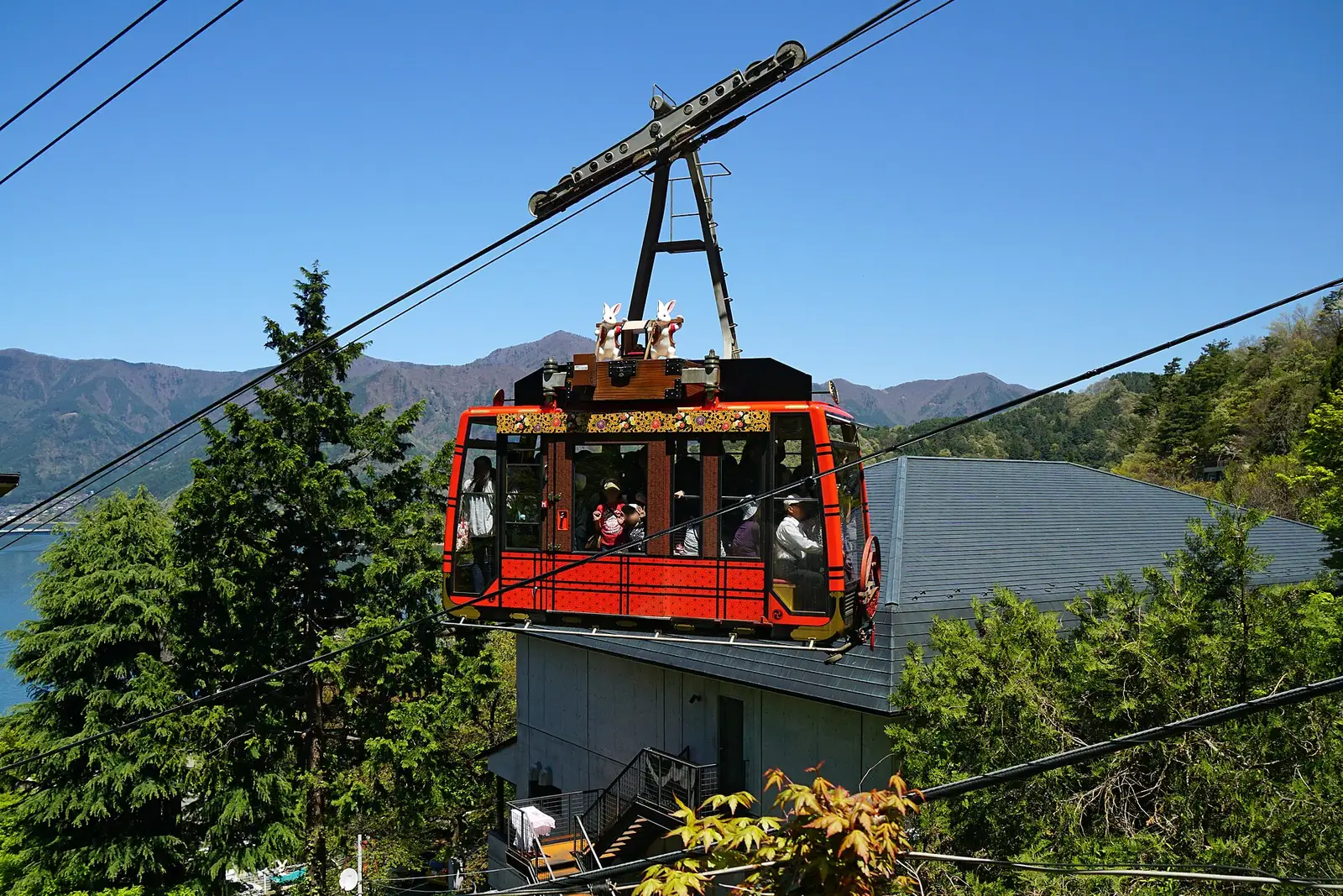 Red Kachi Kachi Ropeway gondola with rabbit figures, Lake Kawaguchi behind