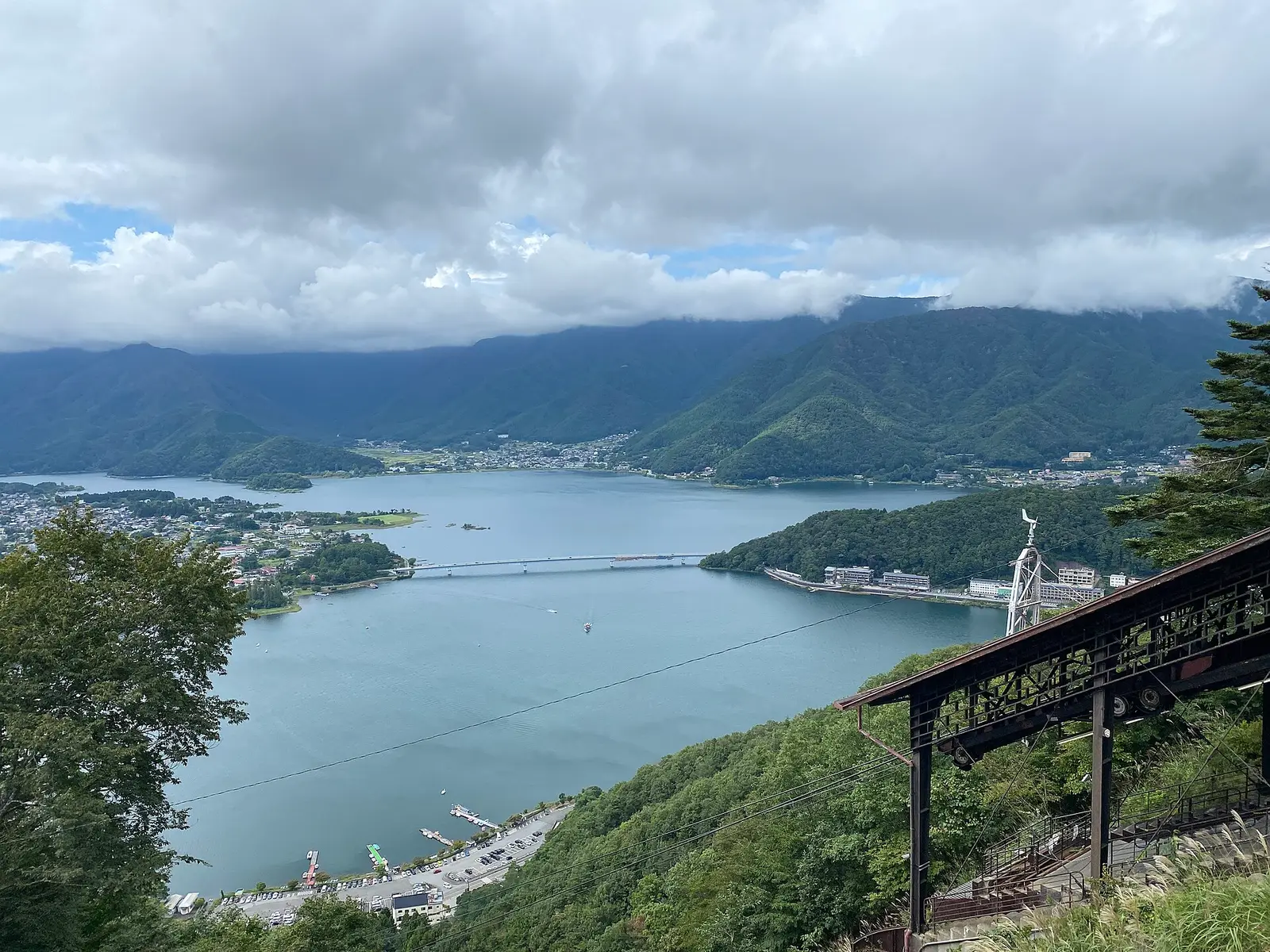 Lake Kawaguchi and its bridge seen from high on Mt Tenjo, ropeway cables and summit station on the right