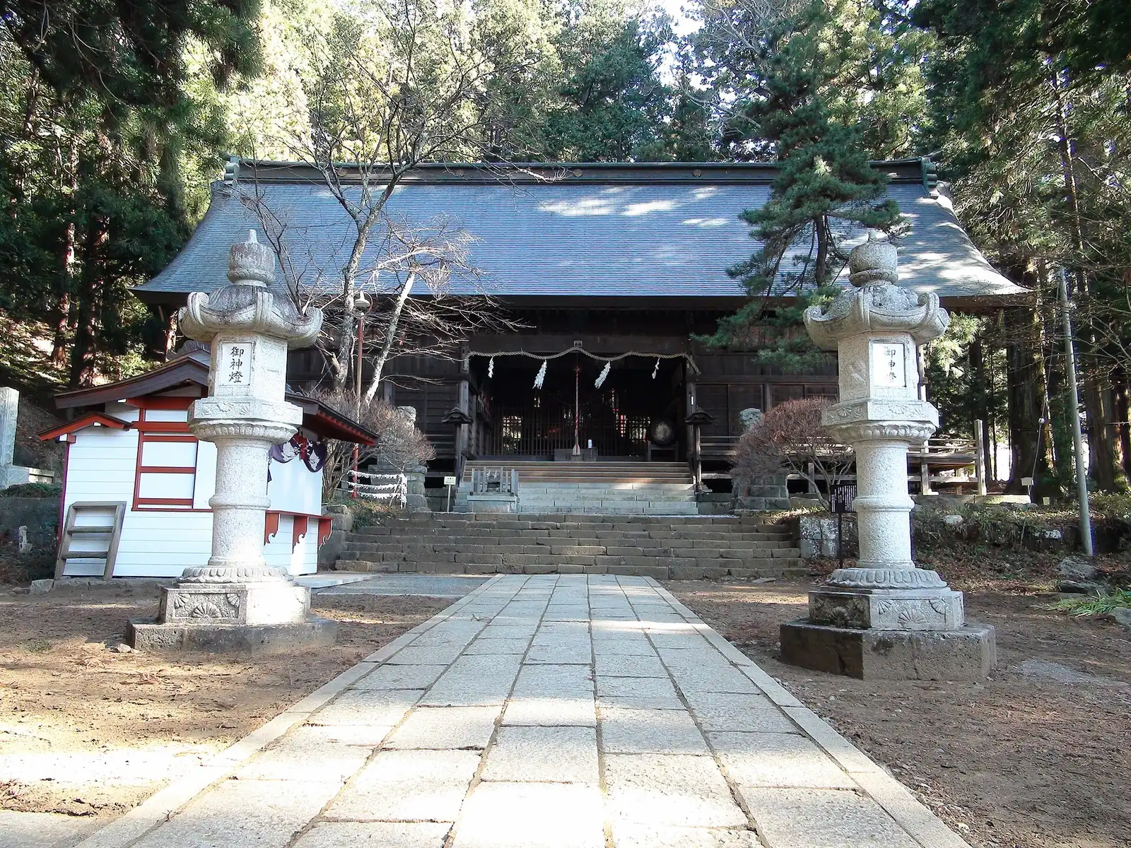 Worship hall of Kawaguchi Asama Shrine with stone lanterns on the approach
