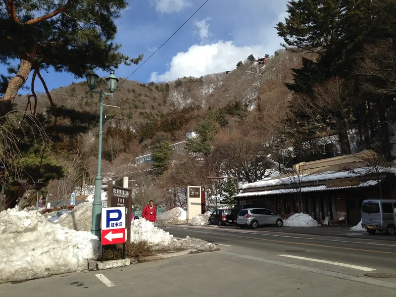 Snow-banked roadside below a wooded hill near Lake Kawaguchi in winter