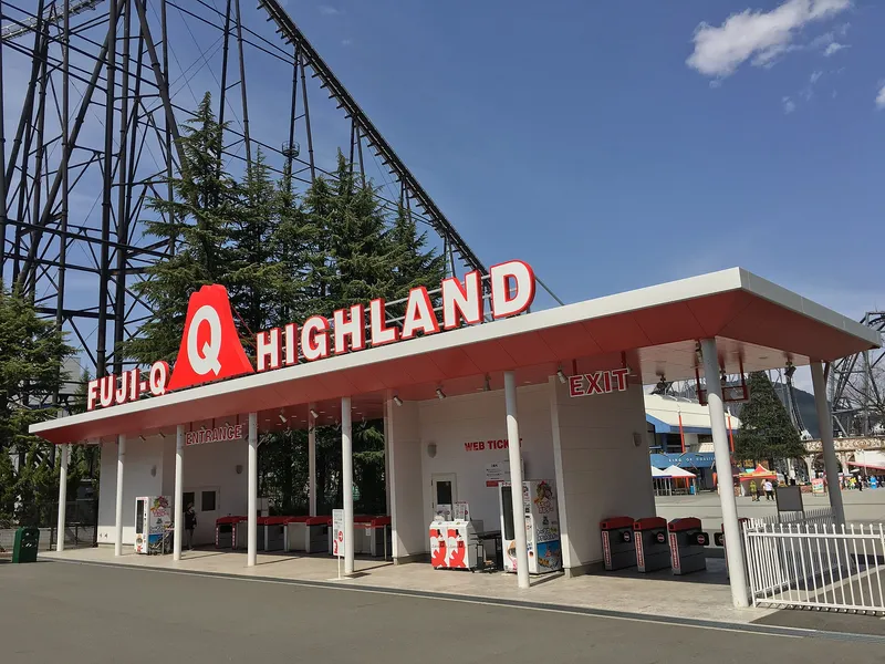 Fuji-Q Highland entrance gate with its sign, roller coaster track behind
