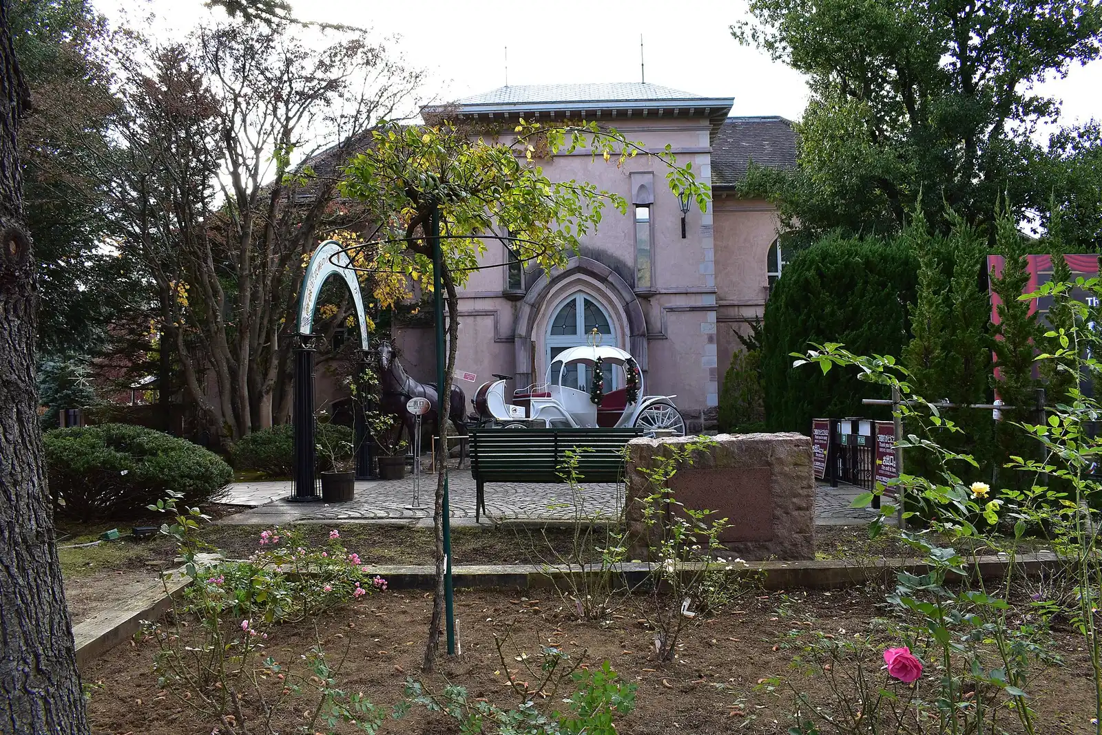 Pink stone building with a white carriage and horse statue, Kawaguchiko Music Forest Museum