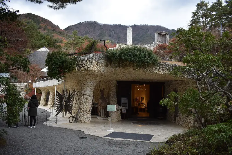 Coral-stone grotto entrance of the Itchiku Kubota Art Museum, autumn hills behind