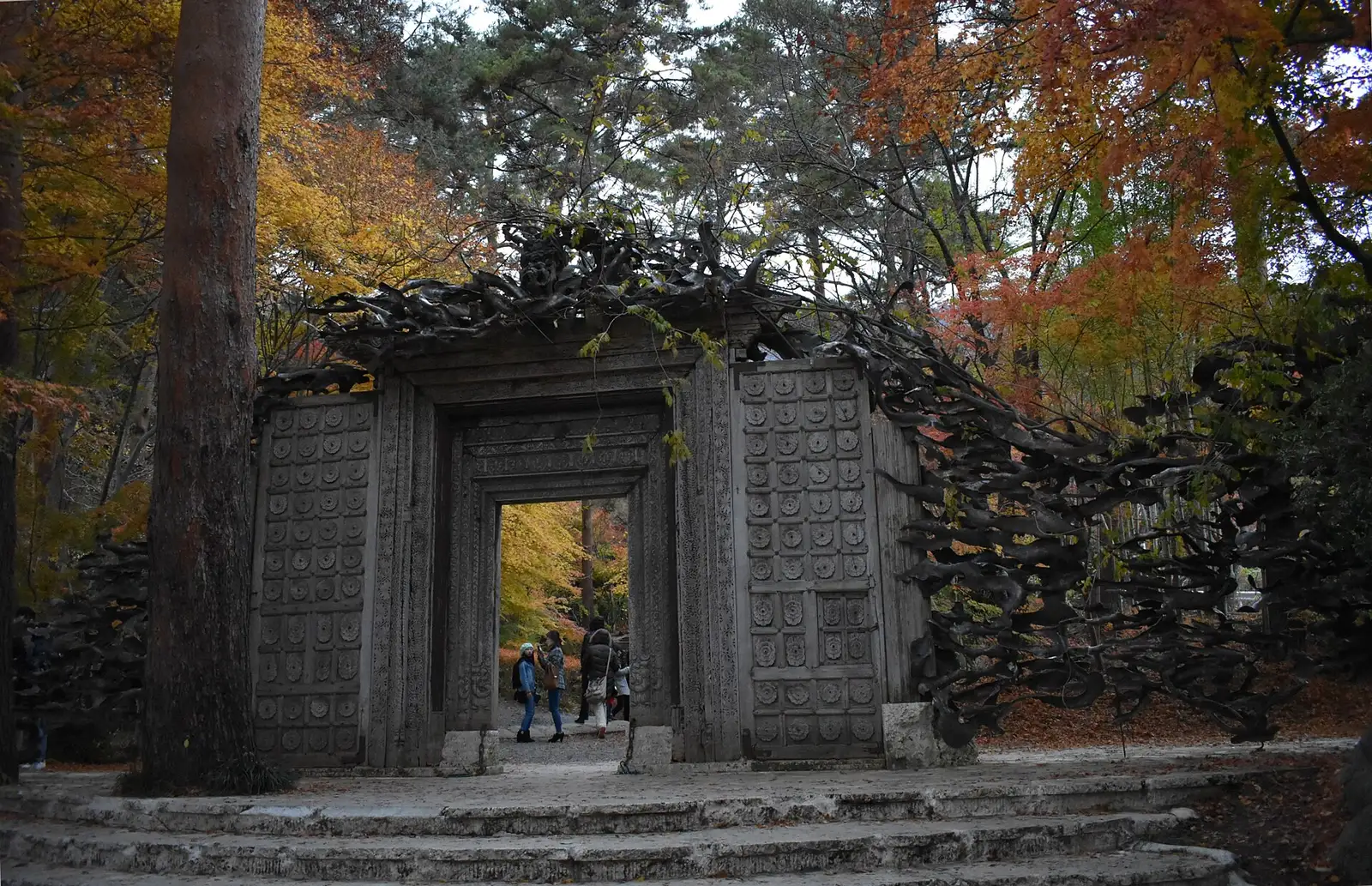 Carved wooden gate of the Itchiku Kubota Art Museum among autumn maples