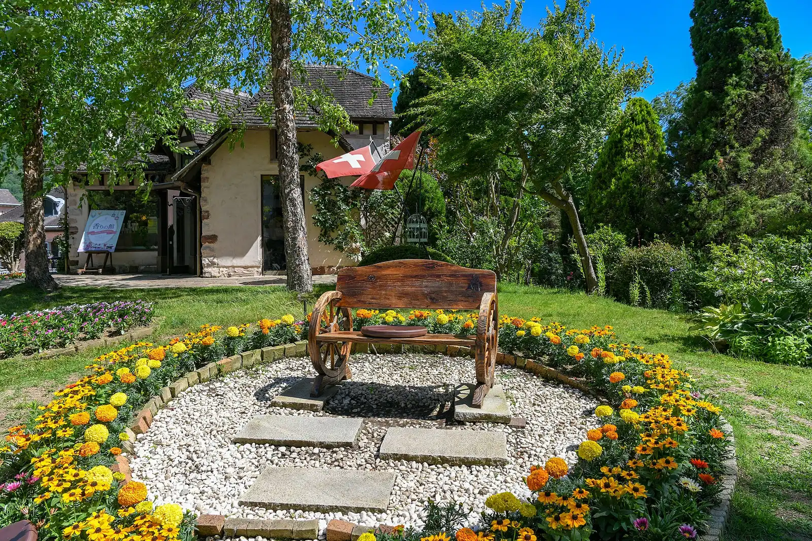 Wagon-wheel bench in a marigold bed in the museum garden