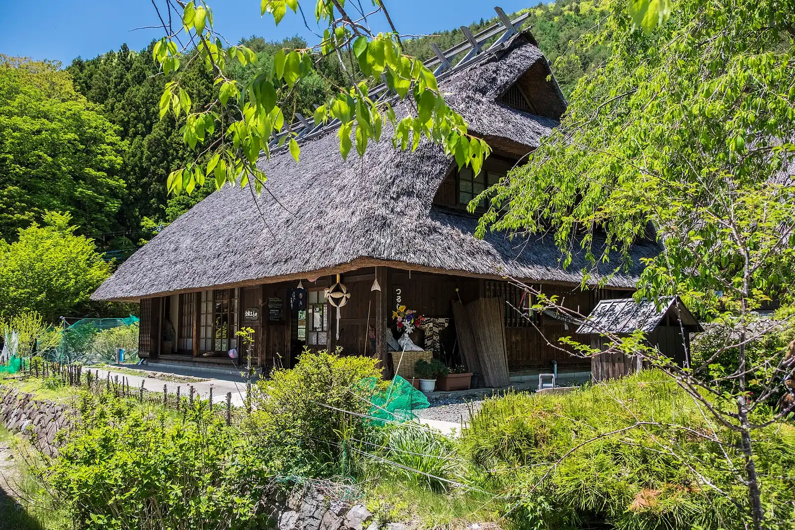 Thatched farmhouse at Iyashi no Sato Nenba in spring, blue sky