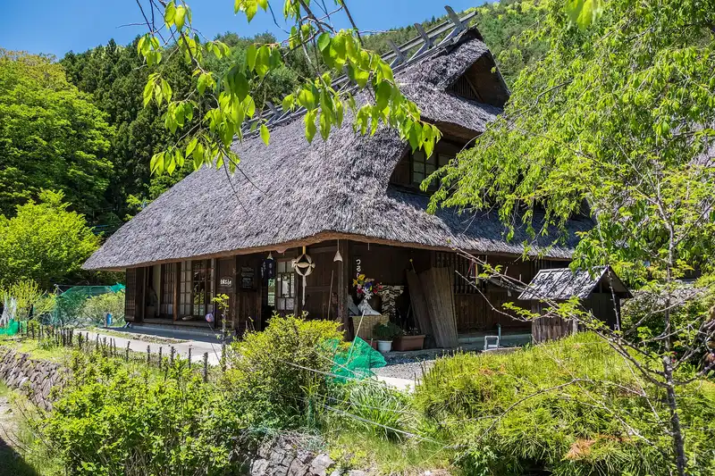 Thatched farmhouse at Iyashi no Sato Nenba in spring, blue sky