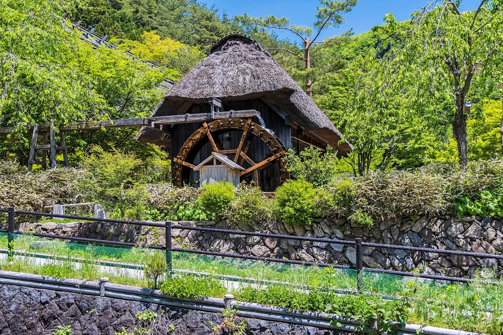 Thatched water-mill hut with a wooden wheel at Iyashi no Sato Nenba